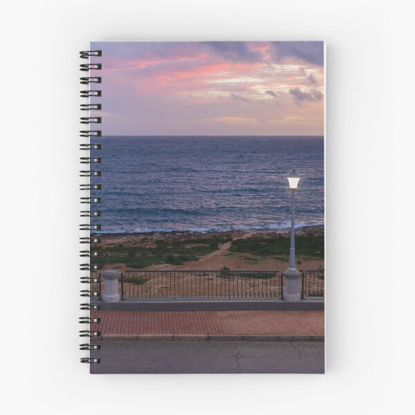 Item preview, Coastal Sunset Over Rocky Shoreline With Lit Lampposts and Distant Headland at Dusk designed and sold by Nmallia.