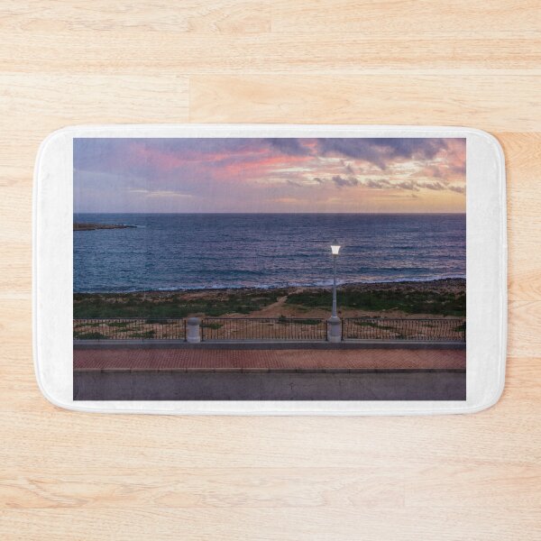 Item preview, Coastal Sunset Over Rocky Shoreline With Lit Lampposts and Distant Headland at Dusk designed and sold by Nmallia.