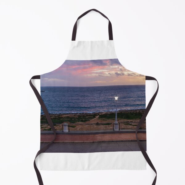 Item preview, Coastal Sunset Over Rocky Shoreline With Lit Lampposts and Distant Headland at Dusk designed and sold by Nmallia.