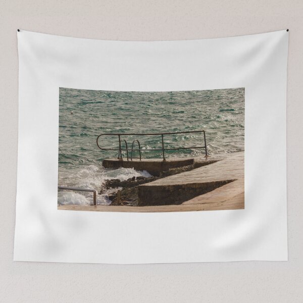 Item preview, Rusty Handrail And Concrete Pier With Ladder Beside Choppy Sea Waves At Coastline designed and sold by Nmallia.