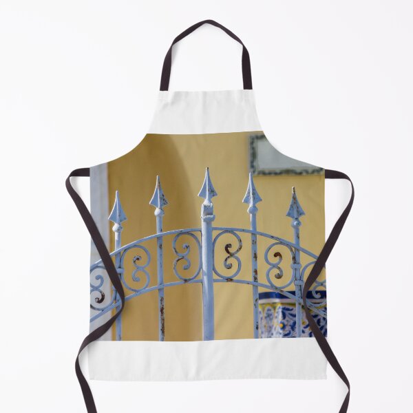 Item preview, Sunlit Ornate Wrought Iron Gate With Rust Patina Against Yellow Wall and Blue Ceramic Planter designed and sold by Nmallia.