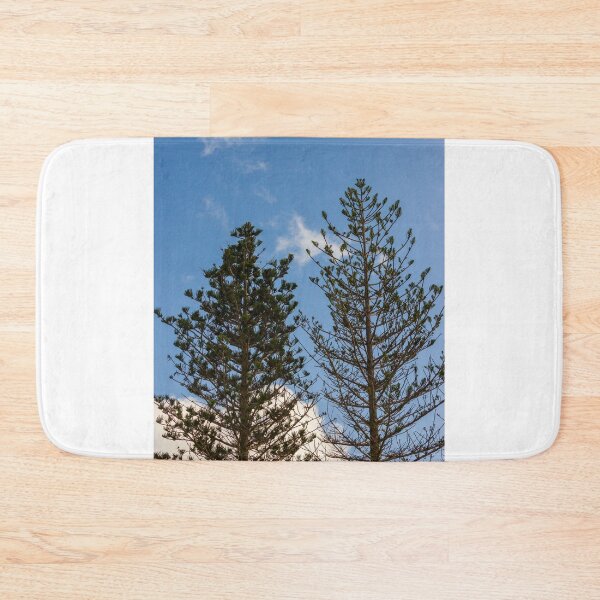 Item preview, Tall Pine Trees Reaching Into A Clear Blue Sky With Scattered White Clouds And Delicate Branches designed and sold by Nmallia.