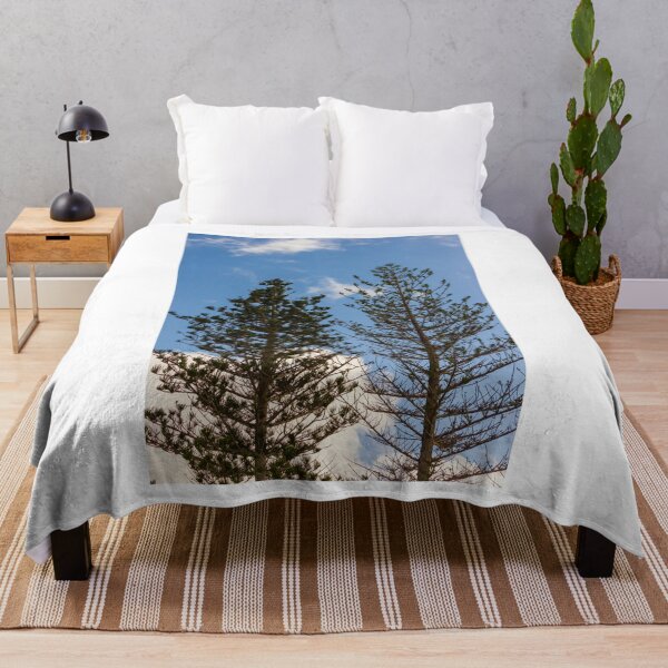 Item preview, Tall Pine Trees Reaching Into A Clear Blue Sky With Scattered White Clouds And Delicate Branches designed and sold by Nmallia.