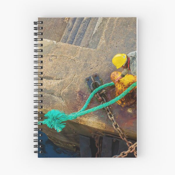 Item preview, Dock Worker Securing Green Mooring Rope To Rusty Bollard On Concrete Pier At Harbor designed and sold by Nmallia.