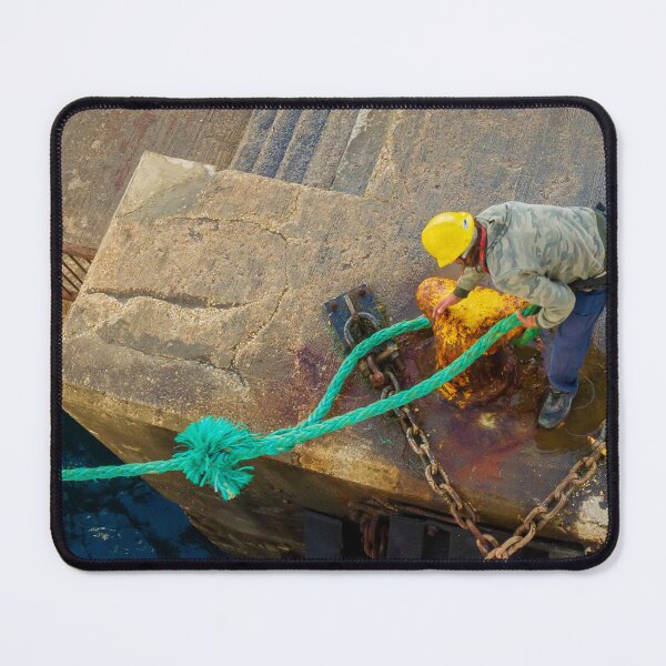 Item preview, Dock Worker Securing Green Mooring Rope To Rusty Bollard On Concrete Pier At Harbor designed and sold by Nmallia.