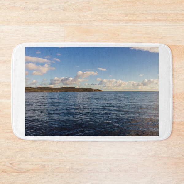 Item preview, Calm Ocean Horizon With Cloud-Filled Sky and Distant Coastal Island at Golden Hour designed and sold by Nmallia.