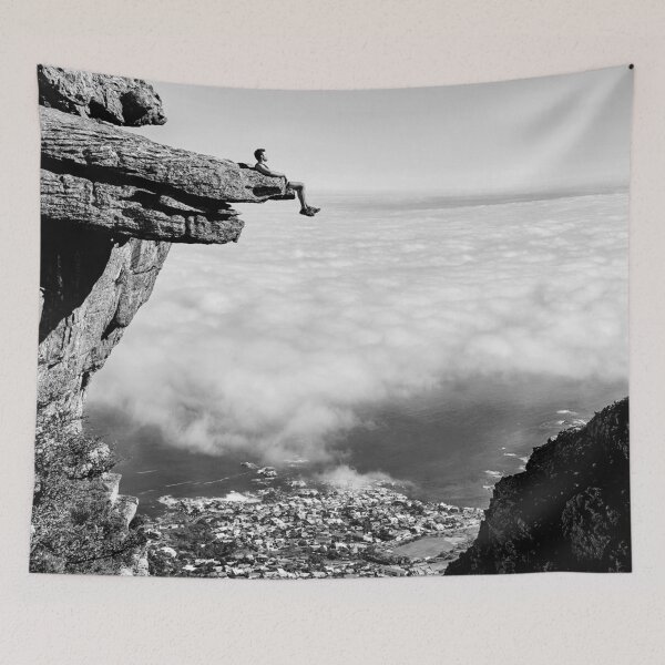 Item preview, On top of the world, daredevil sitting upon rock face cliff black and white fine art photographic art print designed and sold by Astrid Arkhangelsky.