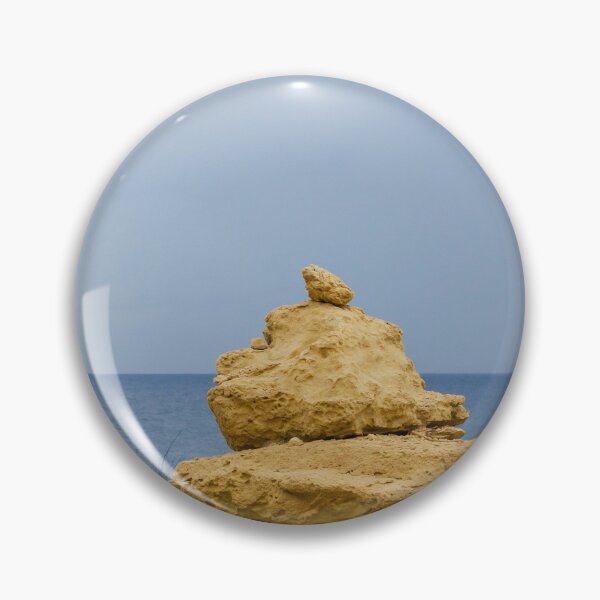 Item preview, Stacked Coastal Rocks Beside Calm Sea Under Cloudy Sky With Green Vegetation And Wildflowers designed and sold by Nmallia.