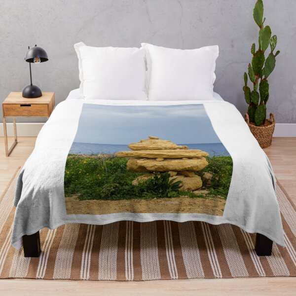 Item preview, Stacked Coastal Rocks Beside Calm Sea Under Cloudy Sky With Green Vegetation And Wildflowers designed and sold by Nmallia.
