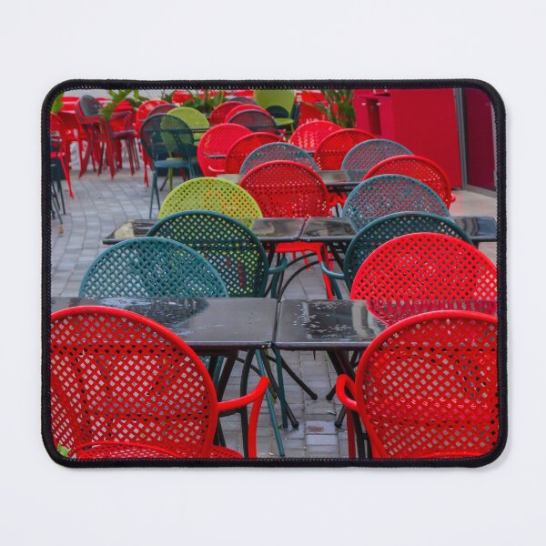 Aperçu de l'œuvre Café coloré en plein air avec chaises en métal rouge et tables noires, aménagé en terrasse urbaine. créée et vendue par Nmallia.
