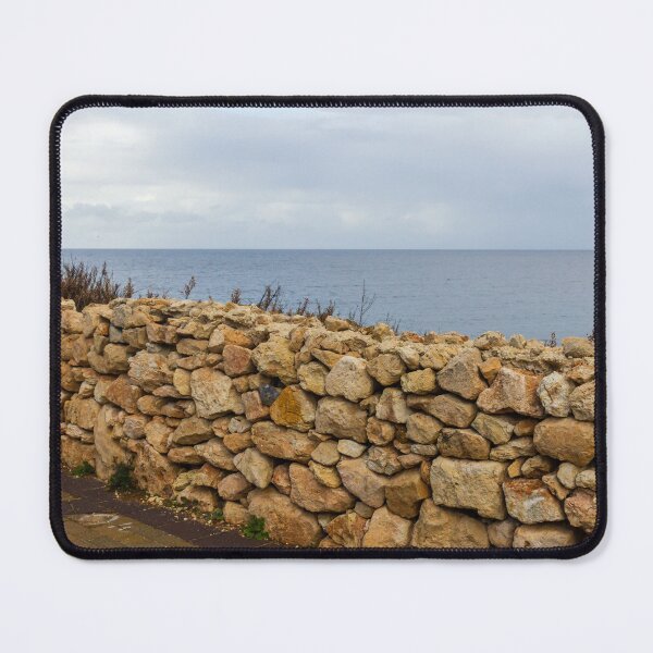 Item preview, Rugged Stone Wall Along Coastal Promenade Overlooking Calm Sea Under Overcast Sky designed and sold by Nmallia.
