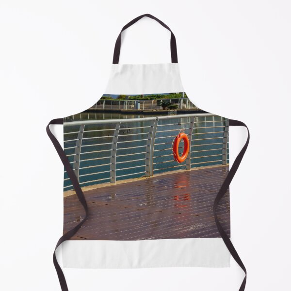 Item preview, Orange Lifebuoy Hanging on Metal Railing Along Waterfront Boardwalk Promenade Over Calm Harbor Water designed and sold by Nmallia.