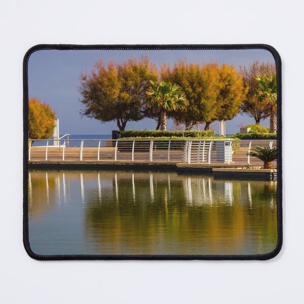 Item preview, Waterfront Promenade With Palm Trees And Reflections On Calm Urban Lagoon designed and sold by Nmallia.