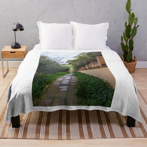 Item preview, Tranquil Paved Garden Path Along Stone Wall Surrounded By Green Foliage And Olive Trees designed and sold by Nmallia.