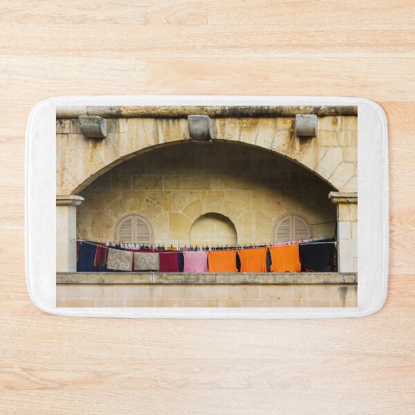 Item preview, Colorful Laundry Hanging On Stone Balcony Under Arched Mediterranean Shuttered Windows designed and sold by Nmallia.