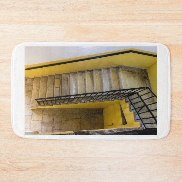 Item preview, Empty Yellow Stairwell With Worn Stone Steps And Black Metal Railing In Apartment Building designed and sold by Nmallia.