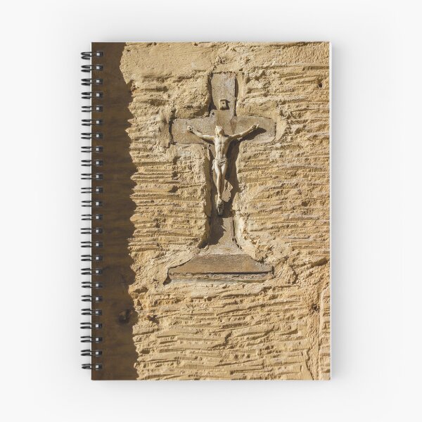 Item preview, Crucifijo desgastado sobre pared de estuco con figura de Cristo en relieve religioso iluminado por el sol. designed and sold by Nmallia.