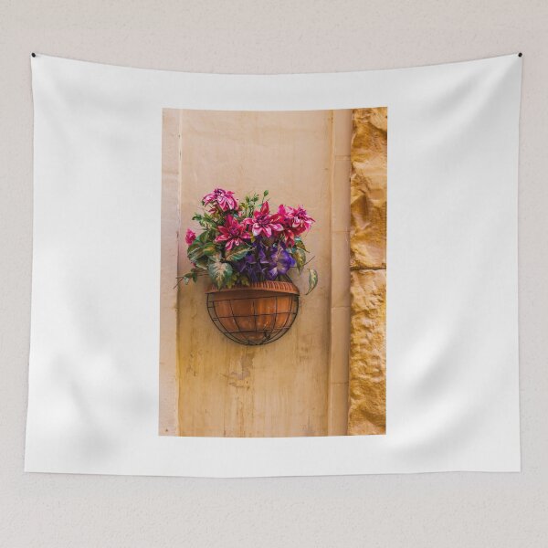 Item preview, Pink And Purple Flowers In Terracotta Wall Planter Pot Against Textured Beige Stucco Wall designed and sold by Nmallia.