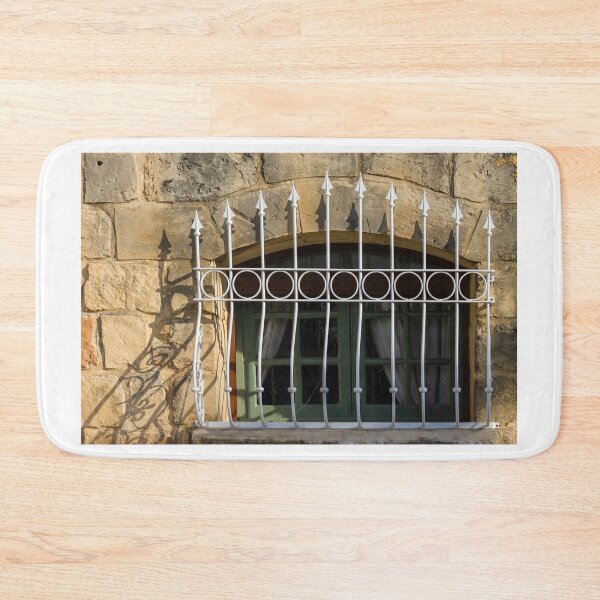 Item preview, Green Arched Window With Decorative White Wrought Iron Bars On Rustic Stone Wall In Sunlight designed and sold by Nmallia.