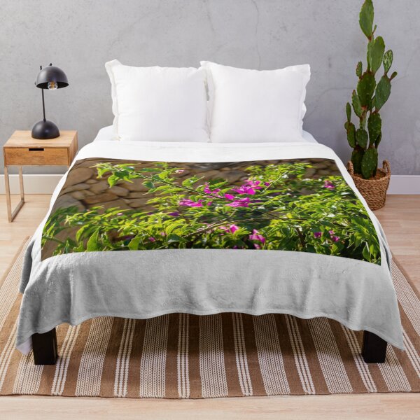 Item preview, Sunlit Pink Bougainvillea Blossoms Against Rustic Stone Wall With Lush Green Leaves Outdoor Garden Branches designed and sold by Nmallia.