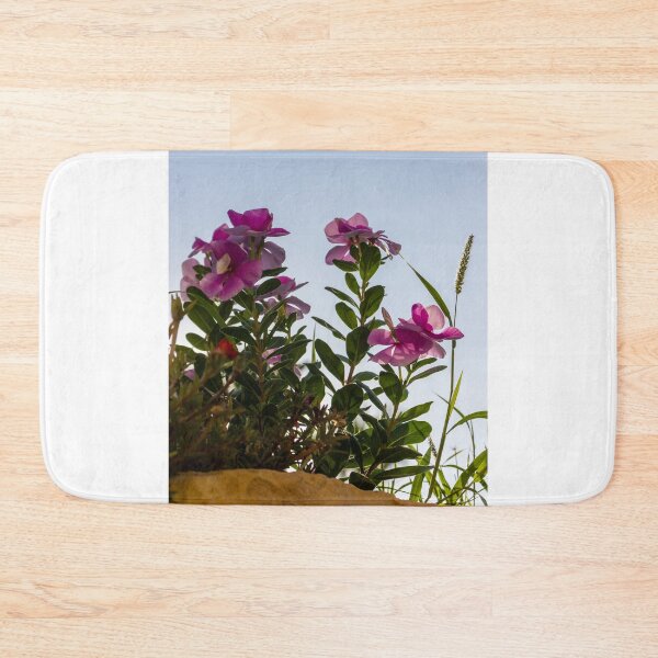 Item preview, Pink Garden Flowers Reaching Toward Blue Sky Over Stone Wall in Warm Sunlight designed and sold by Nmallia.
