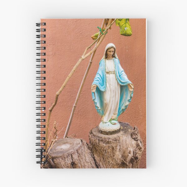 Item preview, Statue Of The Virgin Mary In Blue Robe Standing On Tree Stump Against Terracotta Wall designed and sold by Nmallia.