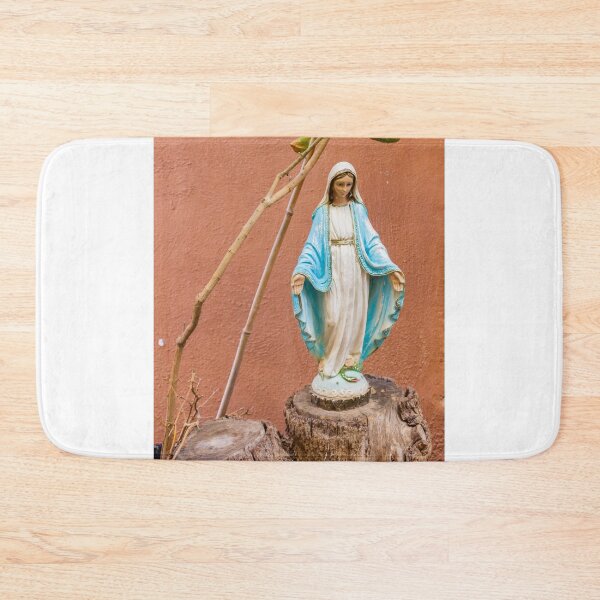 Item preview, Statue Of The Virgin Mary In Blue Robe Standing On Tree Stump Against Terracotta Wall designed and sold by Nmallia.