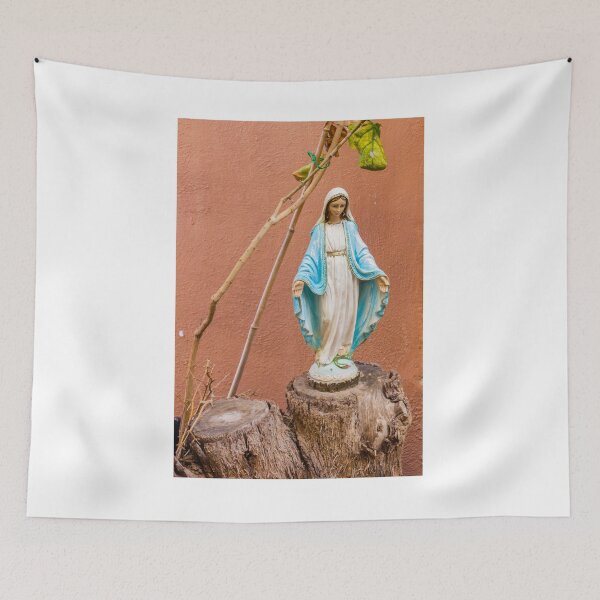 Item preview, Statue Of The Virgin Mary In Blue Robe Standing On Tree Stump Against Terracotta Wall designed and sold by Nmallia.