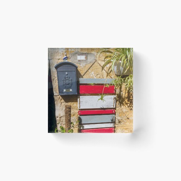Item preview, Rustic Black Mailbox On Sunlit Stone Wall With Red And White Wooden Panels And Potted Plant designed and sold by Nmallia.