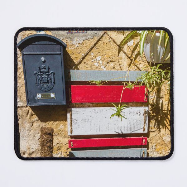 Item preview, Rustic Black Mailbox On Sunlit Stone Wall With Red And White Wooden Panels And Potted Plant designed and sold by Nmallia.