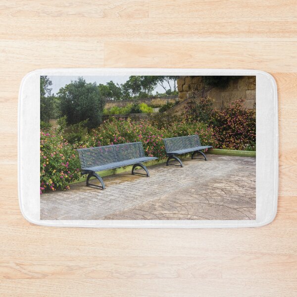 Item preview, Empty Metal Benches in Flower Garden Next to Stone Wall in Outdoor Park designed and sold by Nmallia.