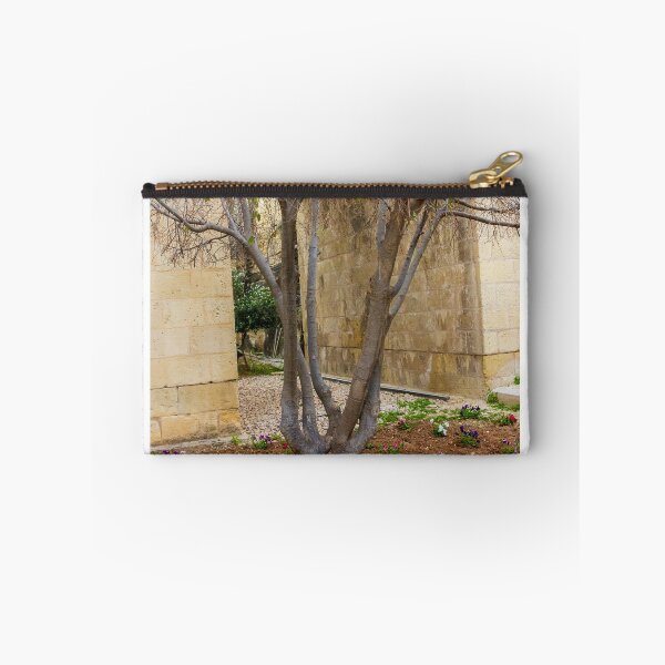 Item preview, Leafless Garden Tree With Colorful Pansies In A Stone Courtyard Beside Historic Wall designed and sold by Nmallia.