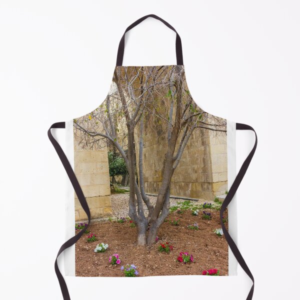 Item preview, Leafless Garden Tree With Colorful Pansies In A Stone Courtyard Beside Historic Wall designed and sold by Nmallia.