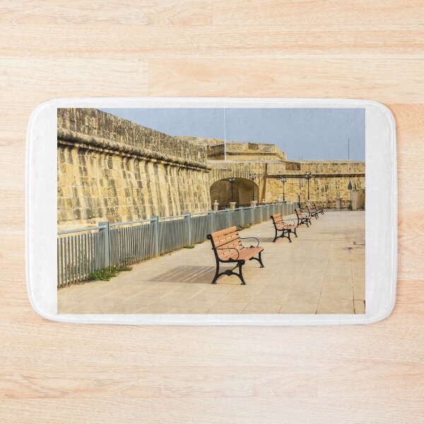 Item preview, Row Of Wooden Benches Along Historic Stone Fort Promenade On Sunny Empty Walkway designed and sold by Nmallia.