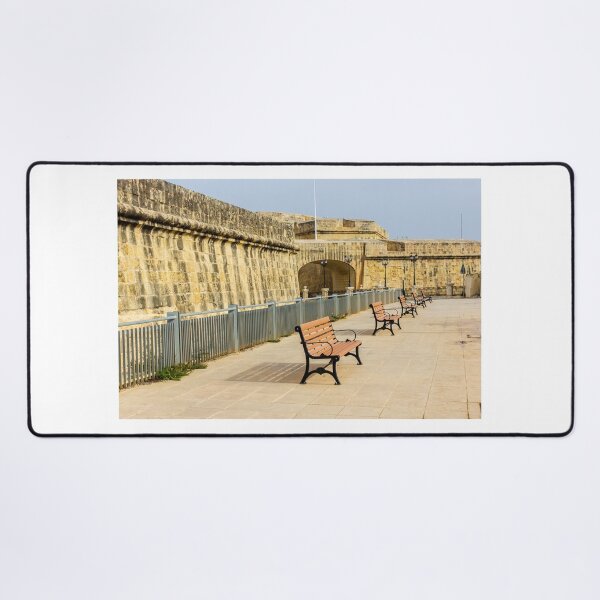 Item preview, Row Of Wooden Benches Along Historic Stone Fort Promenade On Sunny Empty Walkway designed and sold by Nmallia.