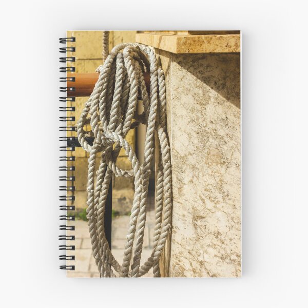 Item preview, Coiled Rope Hanging on Stone Railing Beside Marble Wall with Sunlit Texture and Shadows designed and sold by Nmallia.