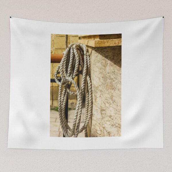 Item preview, Coiled Rope Hanging on Stone Railing Beside Marble Wall with Sunlit Texture and Shadows designed and sold by Nmallia.