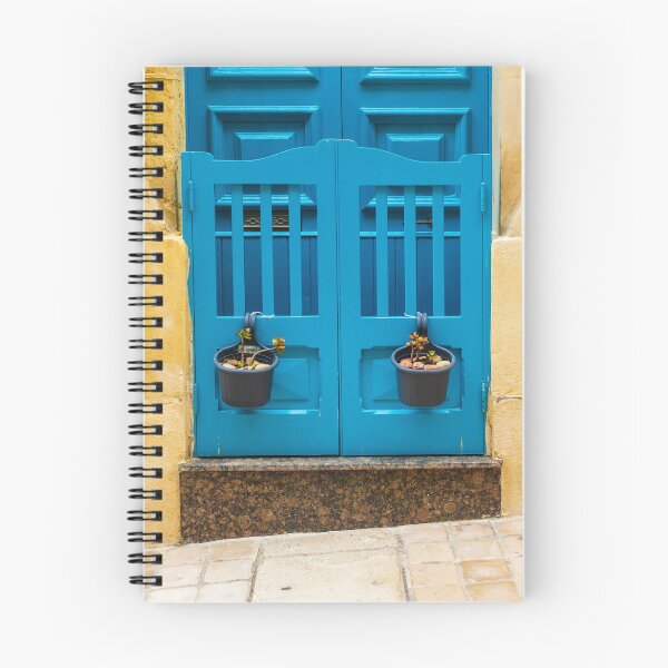 Item preview, Bright Blue Door With Hanging Plant Pots Against Sunlit Yellow Stone Wall In Mediterranean Street designed and sold by Nmallia.