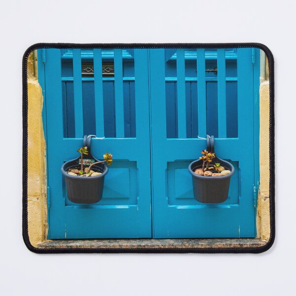 Item preview, Bright Blue Door With Hanging Plant Pots Against Sunlit Yellow Stone Wall In Mediterranean Street designed and sold by Nmallia.