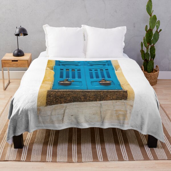 Item preview, Bright Blue Door With Hanging Plant Pots Against Sunlit Yellow Stone Wall In Mediterranean Street designed and sold by Nmallia.
