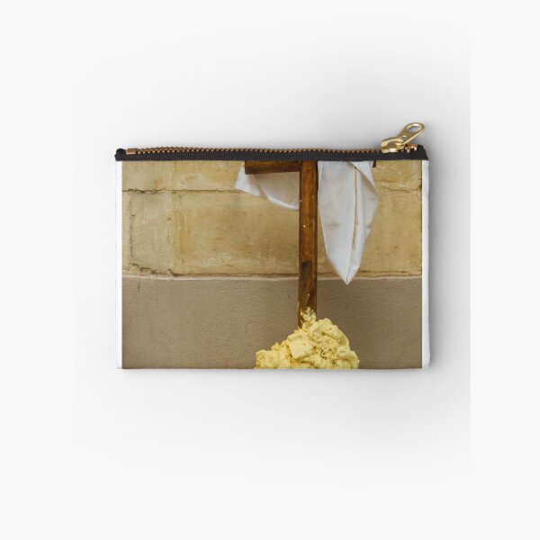 Item preview, Wooden Cross Draped With White Cloth Standing on Yellow Foam Pile Against Stone Wall designed and sold by Nmallia.