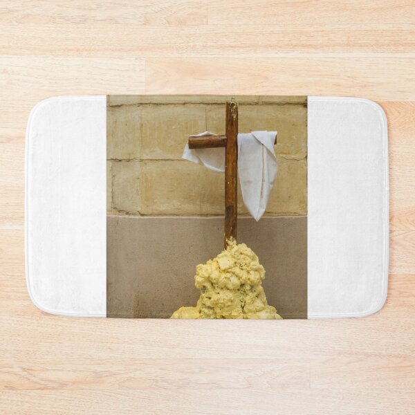 Item preview, Wooden Cross Draped With White Cloth Standing on Yellow Foam Pile Against Stone Wall designed and sold by Nmallia.