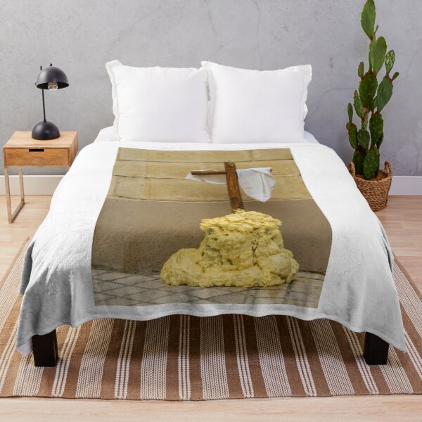 Item preview, Wooden Cross Draped With White Cloth Standing on Yellow Foam Pile Against Stone Wall designed and sold by Nmallia.