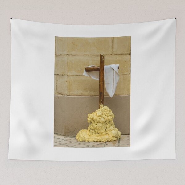 Item preview, Wooden Cross Draped With White Cloth Standing on Yellow Foam Pile Against Stone Wall designed and sold by Nmallia.