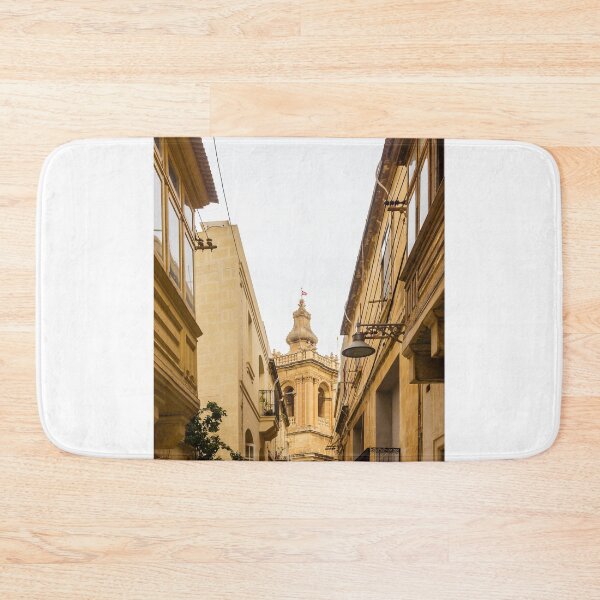 Item preview, Historic Narrow Mediterranean Street Framed By Limestone Buildings With Ornate Church Tower In Background designed and sold by Nmallia.