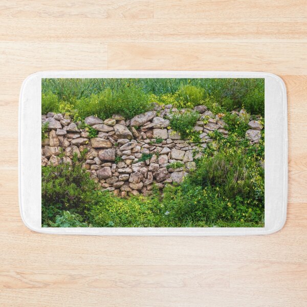 Item preview, Old Dry Stone Wall Covered With Green Vines And Wildflowers In Lush Meadow designed and sold by Nmallia.