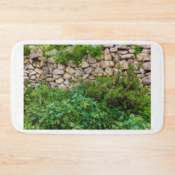 Item preview, Old Dry Stone Wall Covered With Green Vines And Wildflowers In Lush Meadow designed and sold by Nmallia.