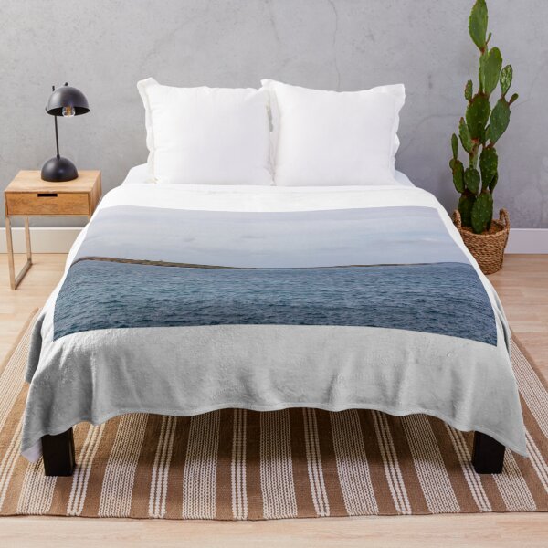 Item preview, Calm Ocean Seascape With Distant Island Lighthouse on Rocky Coastal Horizon Under Overcast Sky designed and sold by Nmallia.