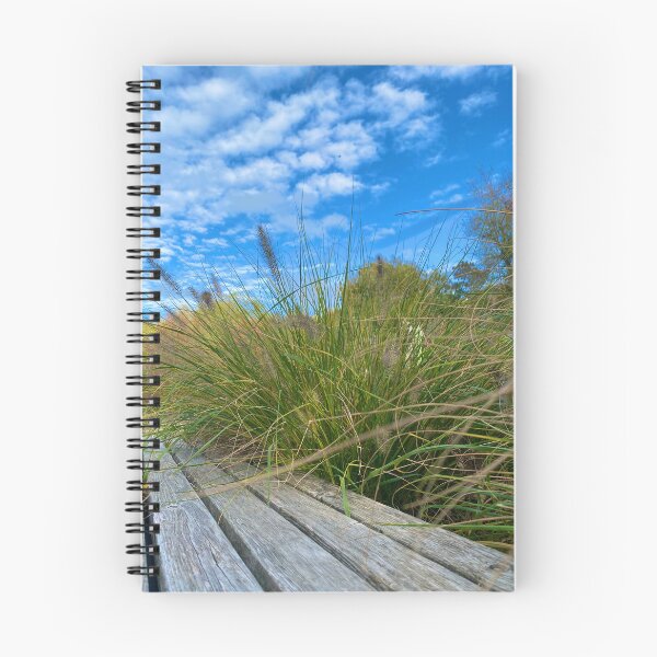Item preview, Fountain grass on a wooden bench against a blue sky designed and sold by GoldenWavesAndWilds.