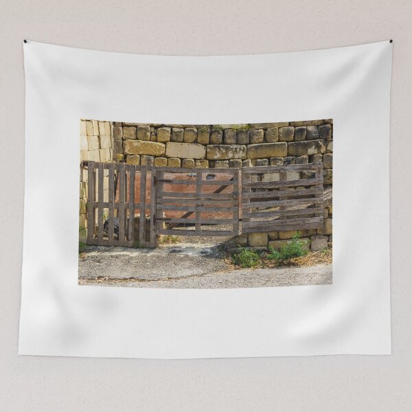 Item preview, Rustic Wooden Gate and Pallet Fence Against Weathered Stone Wall in Rural Farmyard Entrance designed and sold by Nmallia.